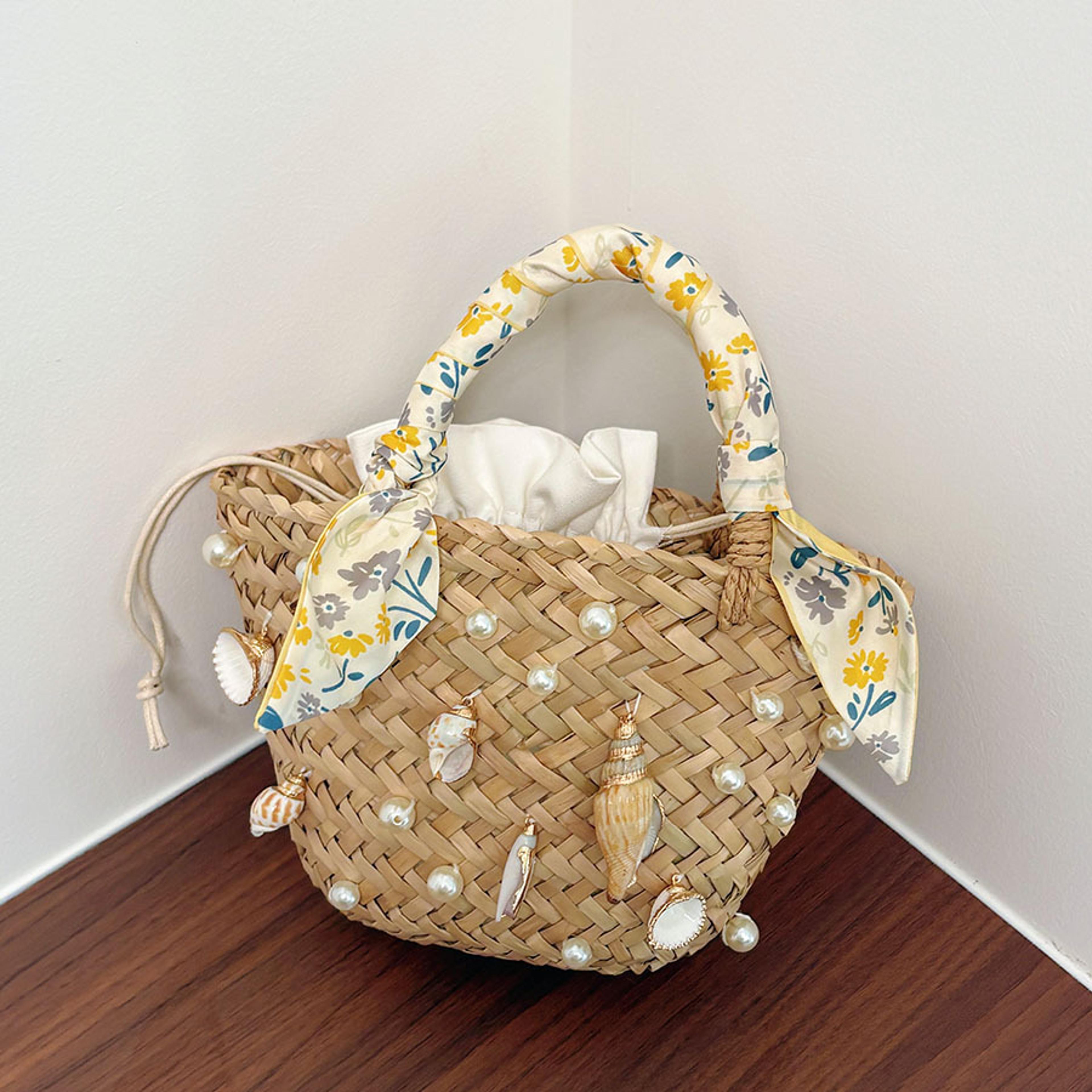 woven straw beach bucket bag with shell accent and ribbon
