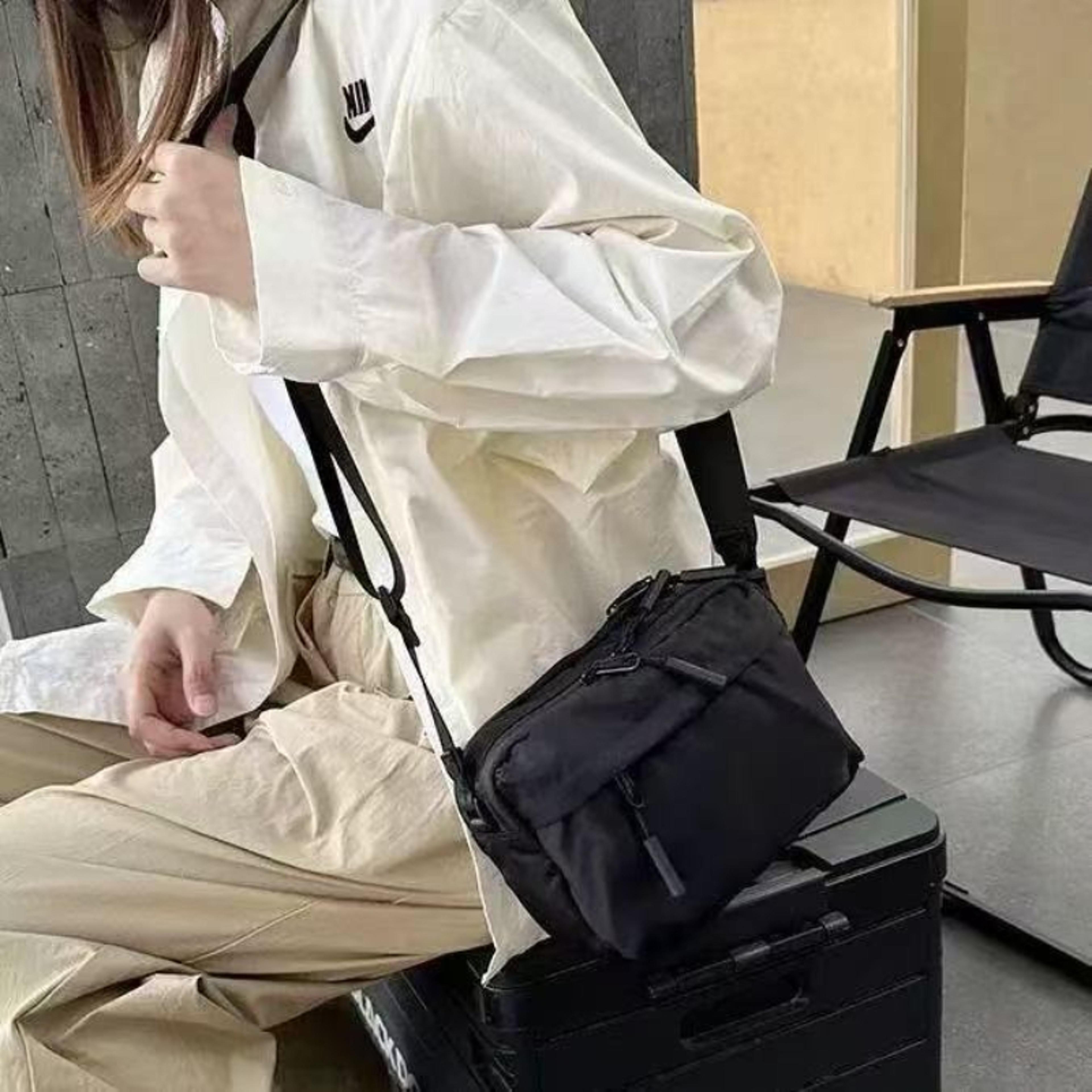 black multi pocket nylon crossbody bag with adjustable strap