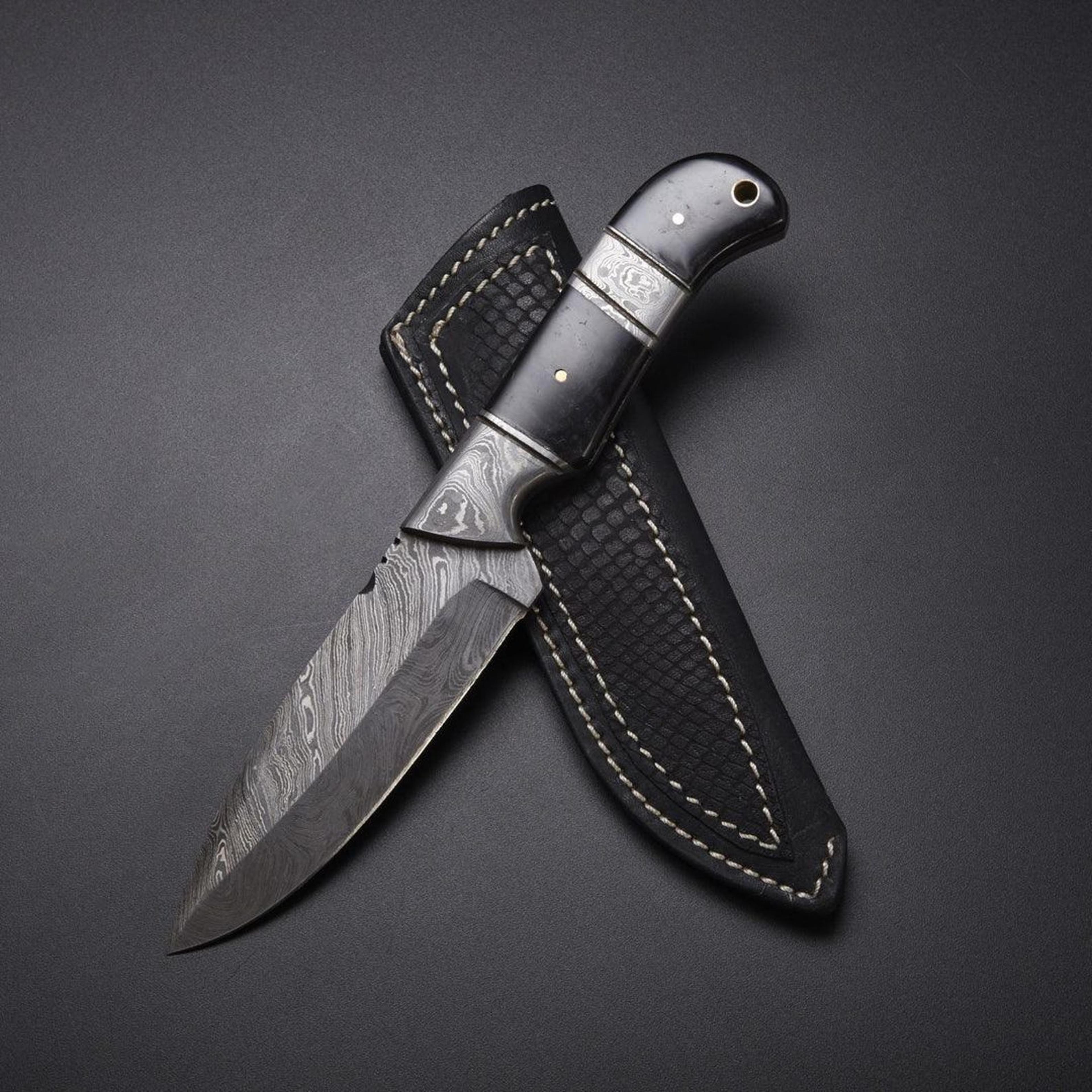 handmade damascus steel hunting knife with buffalo horn handle and leather sheath for outdoor adventures