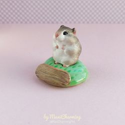 brown and white hamster figurine on the base with nameplate