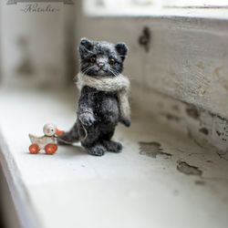 Miniature black plush cat with a wooden duck.