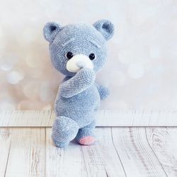 Small teddy bear knitted with blue plush yarn. Soft toy for a child over 3 years.