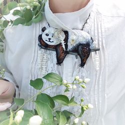 Choker necklace or brooch with panda embroidery on a tree with flowers.