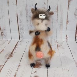 A cow giving milk.Knitted cow. Amigurumi is a toy.Interior toy.Gift.