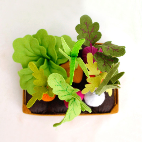 Felt vegetable garden with carrots, beet, garlic, radish, lettuce and onion on the beds top view