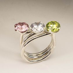 Three silver rings with cubic zirconias.