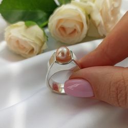 Silver ring with pink pearls.
