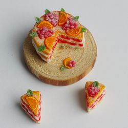 Miniature food for dollhouse, naked cake with oranges and berries with two cut-off pieces at 1:12 scale