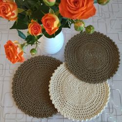 Knitted openwork serving napkins, on the table, for plates. Decor for serving, napkins for a vase, crochetet