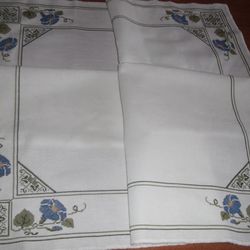 Embroidered tablecloth on the table. Cross stitch. Embroidered tablecloth in flowers.