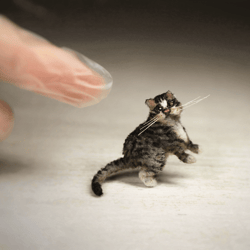 A cat who likes to eat well. Striped cat so very mobile. Realistic pet portrait. Miniature Cat figurine
