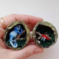 Miniature terrarium made of walnut shell with a chameleon crocheted
