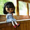 Blythe doll sits on the windowsill