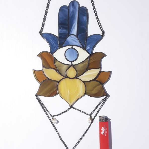 20201108-Blue Stained glass Hamsa hand suncatcher with brown and beige lotus flower next to a red lighter on a white background.jpg