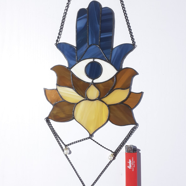 20201108-Blue Stained glass Hamsa suncatcher with brown and beige lotus flower next to a red lighter on a white background.jpg