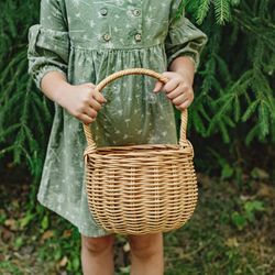 A wicker basket with a handle. Rustic wicker bag. Flower basket. A small wicker basket with a handle. Apple Basket