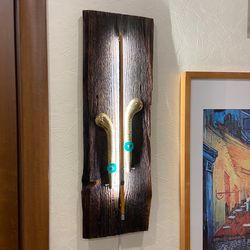 Wall sconce of antiques violin bow and brass pedals from the piano