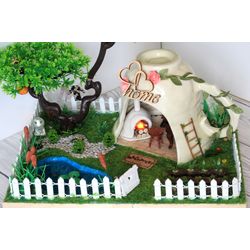 Miniature fairy house in a ceramic cup with light. Dollhouse landscape with pond fish garden tree fence terrarium. Woodl