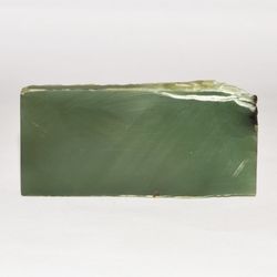 Polished on one side is a plate of uniform greenish-gray jade