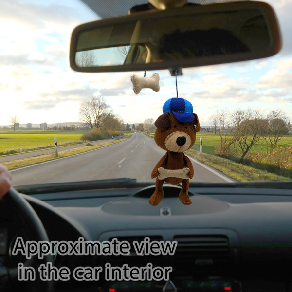 Stuffed dog as a hanging decoration on the rear view mirror in the car.jpg