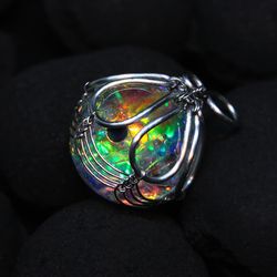 opalescence. pendant - a nebula with a black laboratory opal planets in epoxy resin. stainless steel wire wrap galaxy
