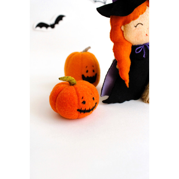 Felt Halloween pumpkins near the witch with a broomstick
