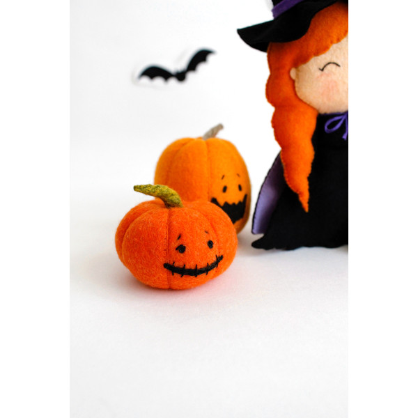 Felt orange Halloween pumpkins near the felt witch with a broomstick