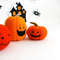 Felt orange Halloween pumpkins standing in the background of painted Halloween decorations, close-up view