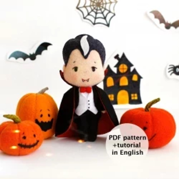 Felt toys - vampire Count Dracula and orange Halloween pumpkins standing in the background of painted Halloween decorations, front view
