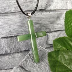 Christian cross pendant made of green natural jade, religious and spiritual jewelry.
