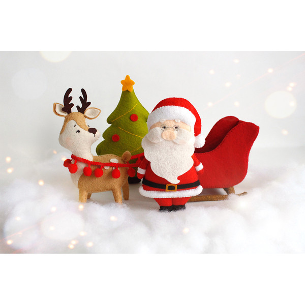Felt Santa Claus, reindeer Rudolph with Santa's sleigh and Christmas tree toys on the "snow"