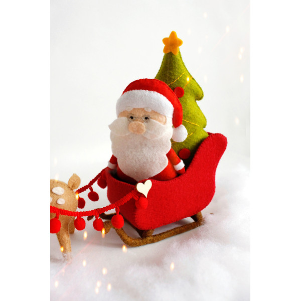 Felt Santa Claus and Christmas tree in the Santa's sleigh near the reindeer Rudolph toys