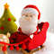 Felt Santa Claus in the Santa's sleigh near the Christmas tree and reindeer Rudolph toys