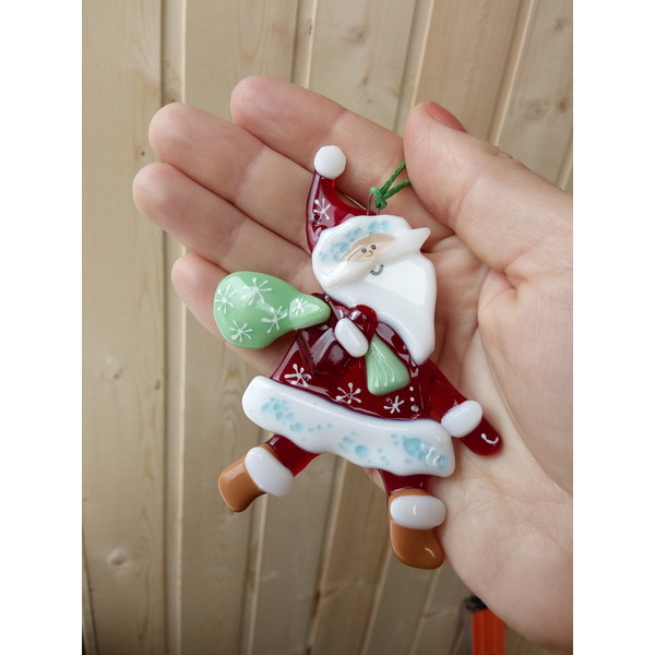 santa claus christmas glass decoration in the palm.jpg