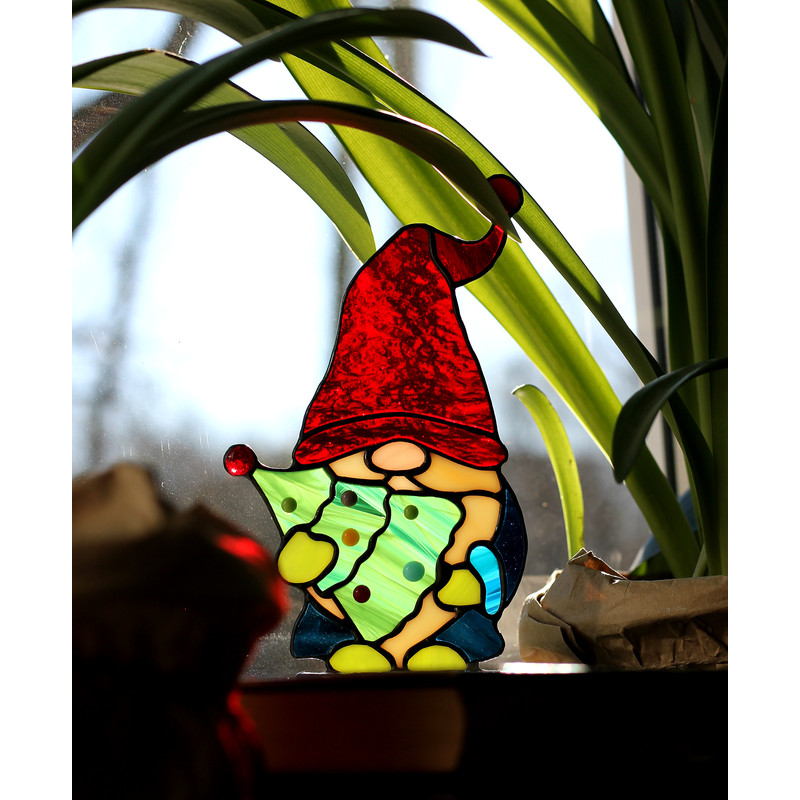Red-gnome-cap-made-of-beautifully-textured-clear-glass-through-which-the-sun's-rays-pass-a-bright-element-of-the-stained-glass-suncatcher-A-gnome-with-a-Christm