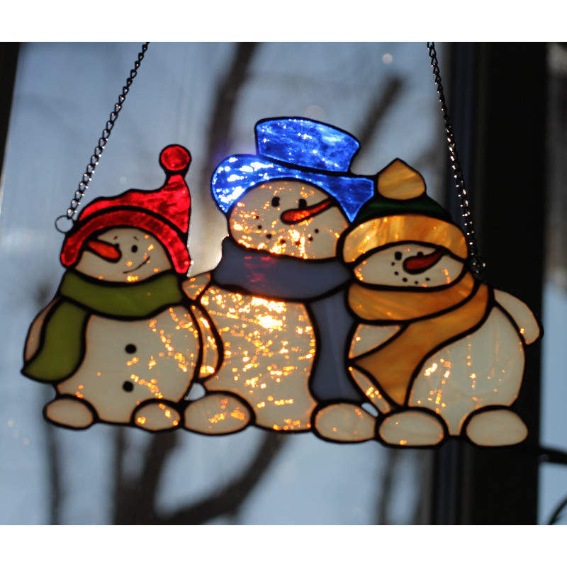 Christmas-stained-glass-suncatcher-family-of-snowmen-hanging-on-window-The-white-glass-of-which-the-snowmen's-bodies-are-made-has-an-unusual-effect-and-shines-w