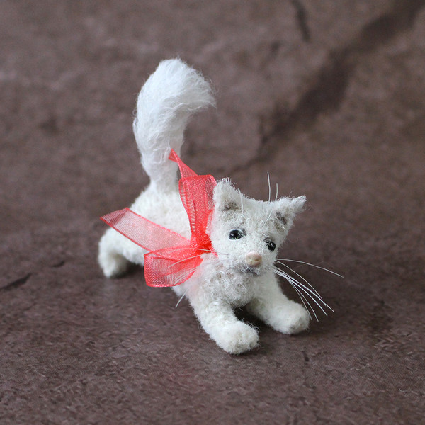 Very realistic small white cat toy.jpg