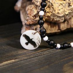 Raven or crow necklace with love rune on the other side. Nacre pearl pendant