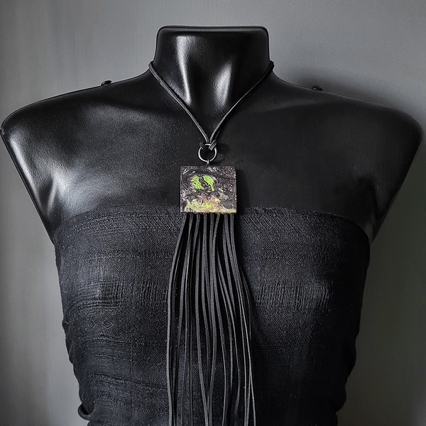 black and green wooden pendant with fringe on mannequin