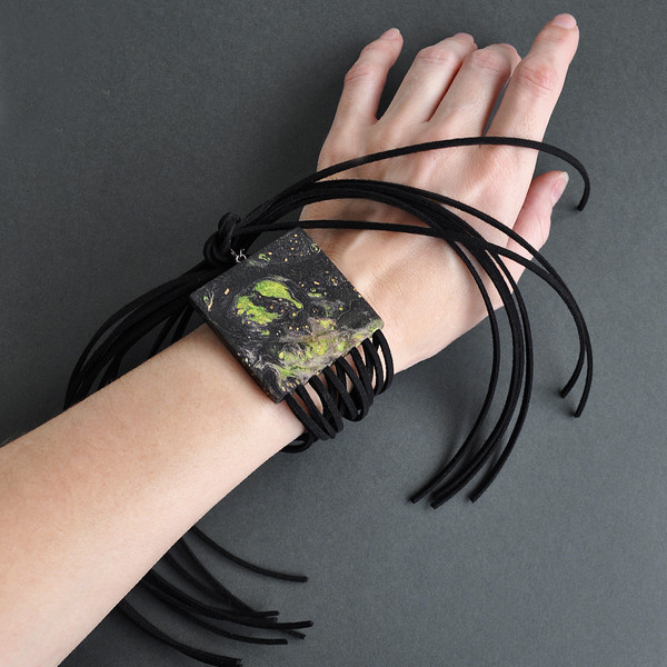 black and green wooden fringe bracelet on hand