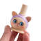 wooden whistle kitty with a light purple bandage