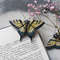 Yellow butterfly swallowtail sits on a book