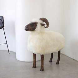 Big life-size Ram lamb chair in Lalanne style. Interior statue animal.Sheepskin stool minimalist decor or wabi sabi. Art