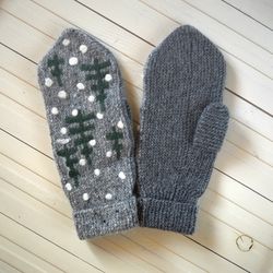 Mittens. Snowing in the winter fir forest. Natural wool. Grey color. Warming for cold weather. Knitted handmade work.