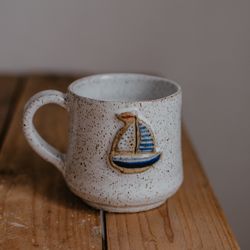 Handmade ceramic mug with a little sailboat