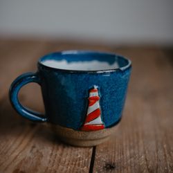 Handmade ceramic mug with a lighthouse