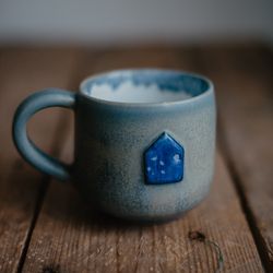 Handmade ceramic mug with a tiny blue house