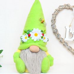 Summer gnome in a green hat with daisies, berries and bee