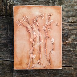 Terracotta wall decor. The first spring plants depicted in a botanical bas-relief