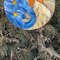 Stained glass Yin Yang dreamcatcher in blue and yellow colors with sun and moon is hanging in front of a Thuja tree.jpg